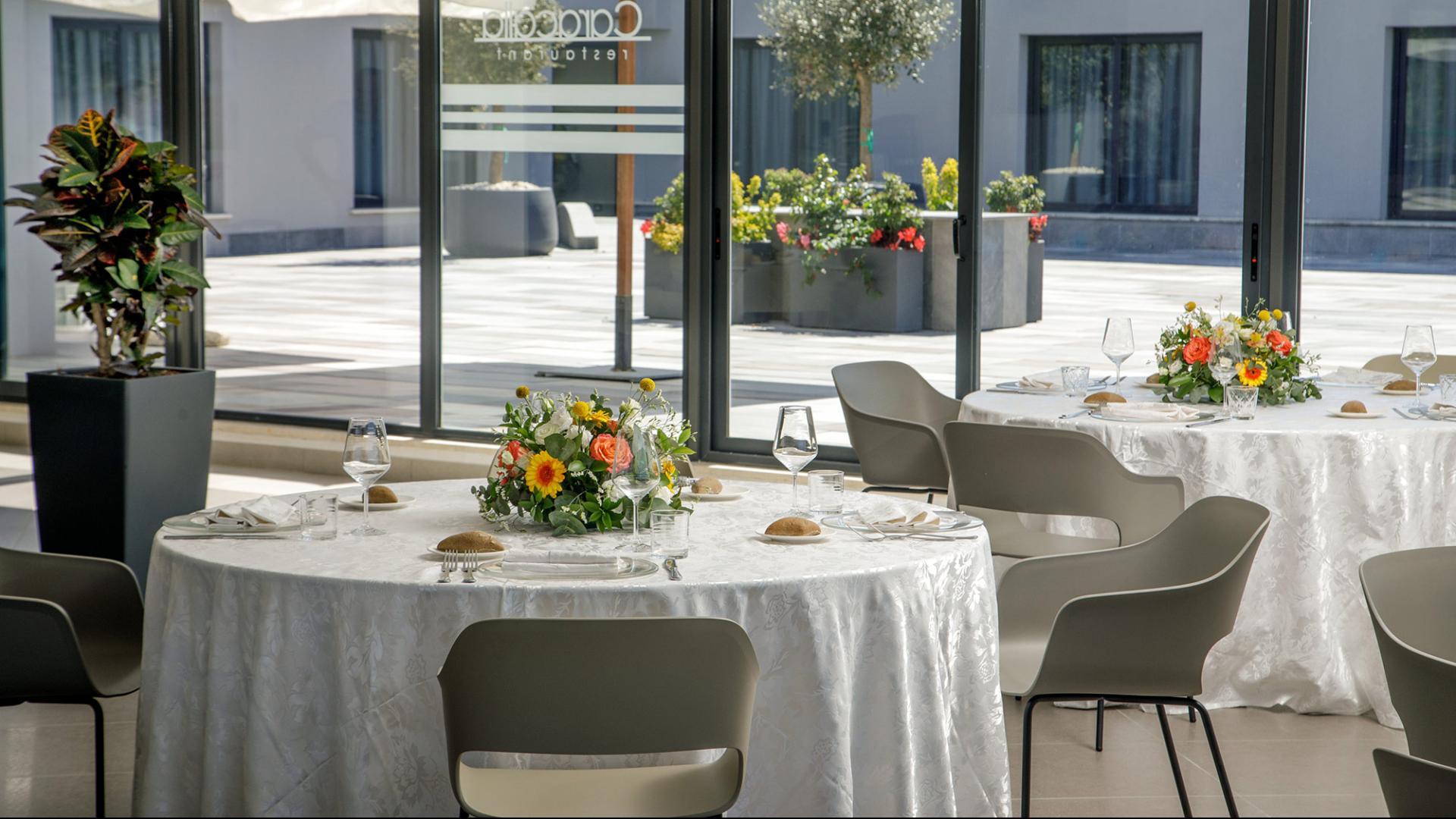 Tavola elegante con decorazioni dorate, fiori e pane, atmosfera festosa e raffinata.