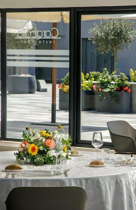 Elegante sala da pranzo con fiori colorati, luce solare e atmosfera raffinata.