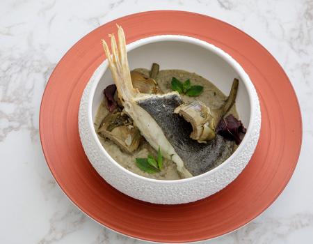 Piatto elegante: pesce su crema di carciofi, decorato con erbe fresche.