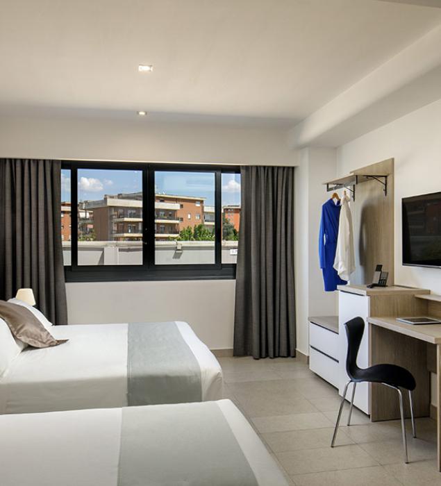 Modern, bright room with two beds, city view.
